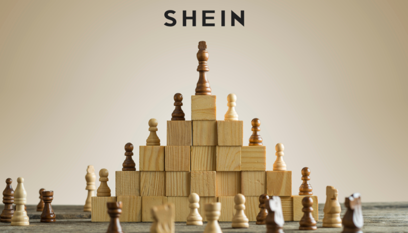Peças de xadrez empilhadas em um pódio com logo da Shein no topo