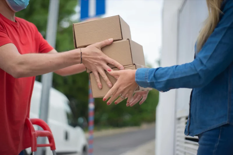 Entregador fazendo uma entrega a uma cliente