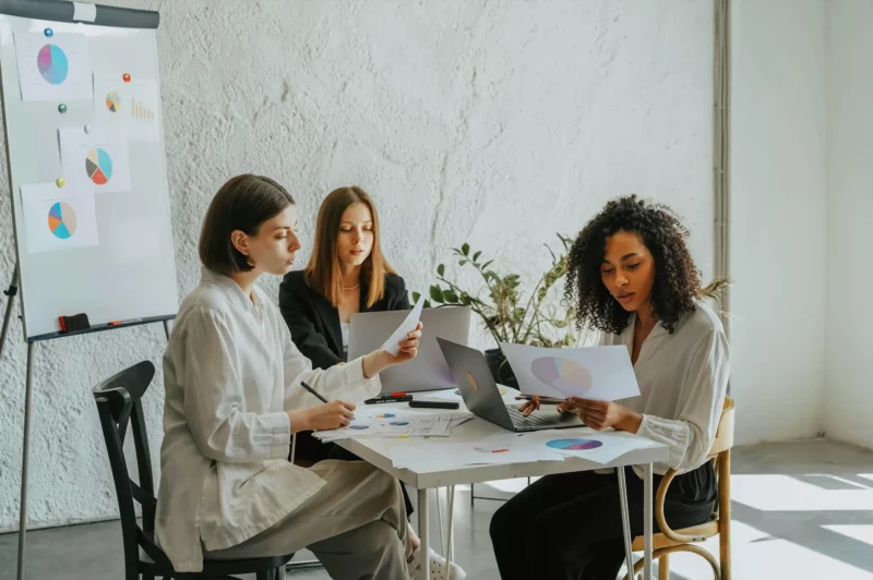 Mulheres trabalhando juntas e analisando dados.